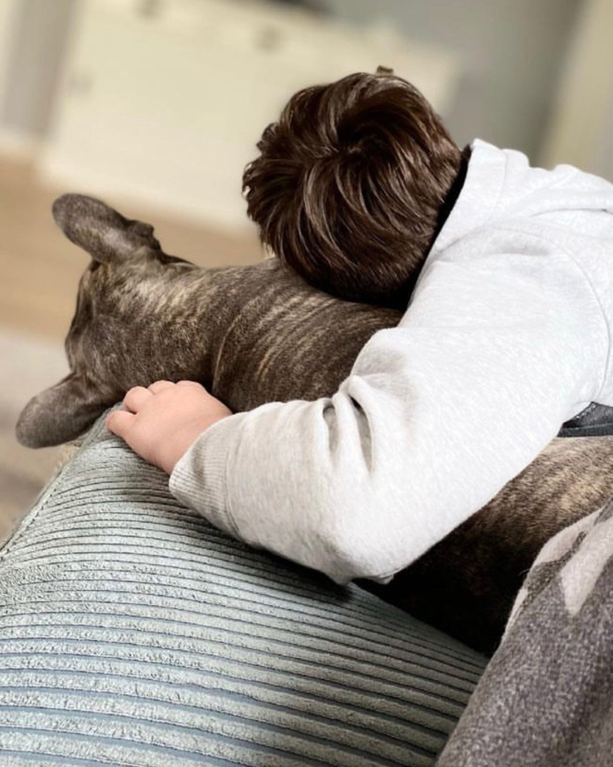 Kind lehnt sich ruhig an seinen Hund